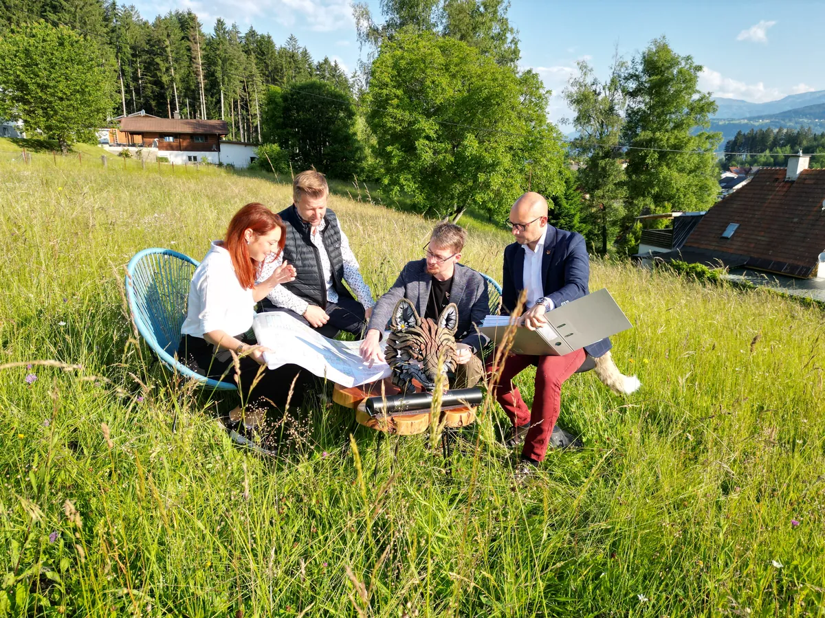 Projektstart von FUXZONE Drautal: das Team mit Plänen und Laptop auf der grünen Wiese.