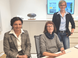 Drei Mitarbeiterinnen der Max Netter GmbH im Büro vor einem Bildschirm mit dem Logo von Netter Bau Art.